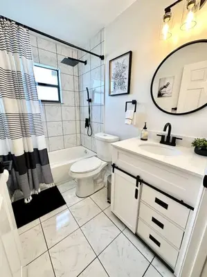 a bathroom with a sink and a toilet and a mirror at Superhost FREE Heated Pool 9 minutes to MCO 15 minutes to Disney in Kissimmee