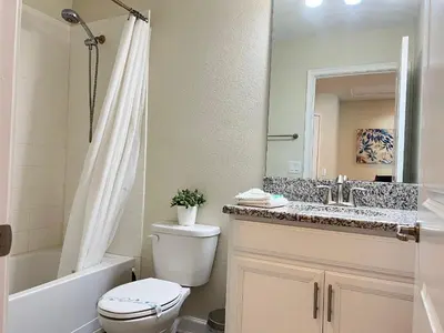 a bathroom with a toilet and a sink and a mirror at Wonderful home close to disney & universal in Kissimmee