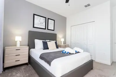 a bedroom with a large white bed and a night stand at Spacious & Comfy Retreat Prime Location Amazing in Kissimmee