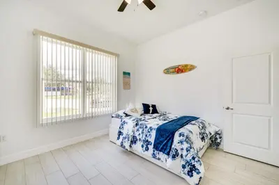 a bedroom with a bed with a blue and white blanket at 3 Mi to Lakefront Beach St Cloud Apt in Ashton