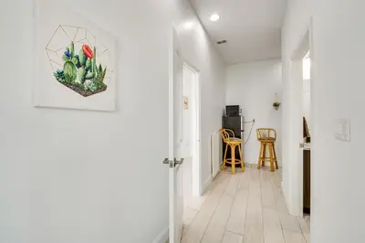 a white hallway with a door and a painting on the wall at 3 Mi to Lakefront Beach St Cloud Apt in Ashton