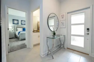a bedroom with a bed and a mirror and a table at Fantastic 4 Bd w Pool at Storey Lake Resort 2709 in Kissimmee