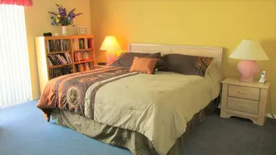 a bedroom with a bed and a book shelf at Christine's Villa in Kissimmee