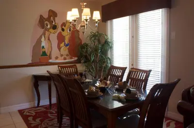 a dining room with a table with chairs and a painting at Princess Hideaway in Orlando