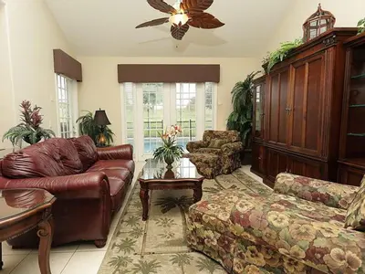 a living room with a leather couch and a table at Princess Hideaway in Orlando