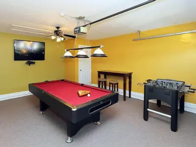 a room with a pool table and a tv at Princess Hideaway in Orlando