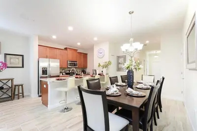a dining room and kitchen with a table and chairs at Stunning Storey Lake Villa Prime Location in Kissimmee