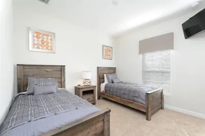 a bedroom with two beds and a flat screen tv at Stunning Storey Lake Villa Prime Location in Kissimmee