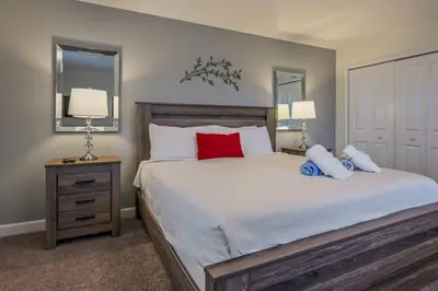 a bedroom with a large bed with red pillows at Luxury Storey Lake Retreat - Spacious Disney-Near in Kissimmee
