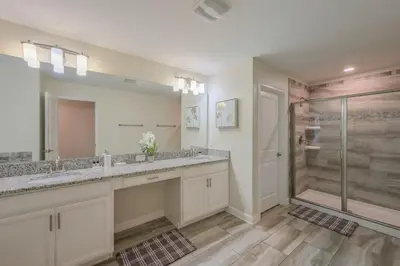 a bathroom with two sinks and a shower at Luxury Storey Lake Retreat - Spacious Disney-Near in Kissimmee