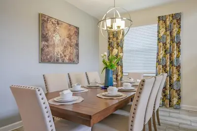 a dining room with a wooden table and chairs at Luxury Storey Lake Retreat - Spacious Disney-Near in Kissimmee