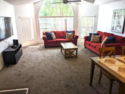 a living room with two red couches and a table at Cozivill in Kissimmee