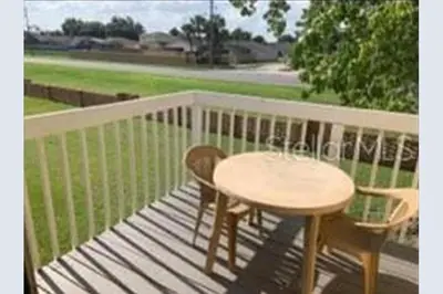a wooden deck with a table and chairs on a porch at Cozivill in Kissimmee