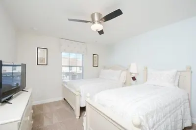 a bedroom with two beds and a ceiling fan at Private Pool Prime Location Beautiful Home in Kissimmee