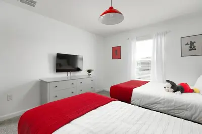 a bedroom with two beds with a teddy bear on top of them at Charming Mickey-Themed Home Prime Location in Kissimmee