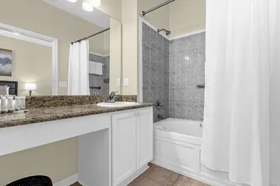 a bathroom with a sink and a tub and a shower at Luxury 4BR Home - Private Pool BBQ - Near Disney in Kissimmee
