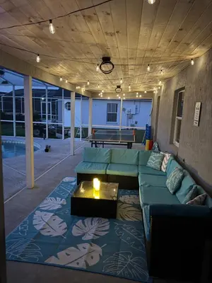 a large living room with a couch and a table at Luxury Waterfront 3b2b Heated Pool , Game Room , Piano House in Kissimmee