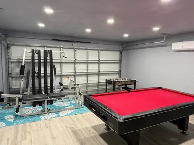 a room with a pool table and a gym at Luxury Waterfront 3b2b Heated Pool , Game Room , Piano House in Kissimmee