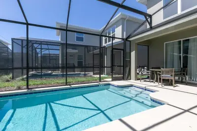a swimming pool in front of a house at Chic & Spacious Best Vacation Home in Kissimmee
