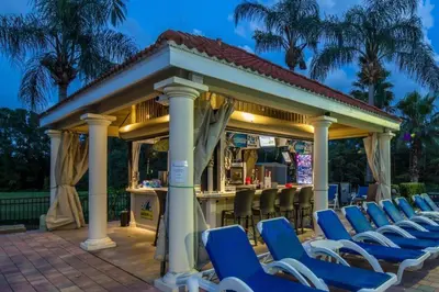 a gazebo with blue chairs and a bar at bsv_villa2633 in Kissimmee