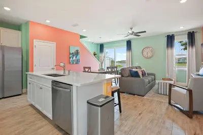 a kitchen with a sink and a living room at Surfstyle at Margaritaville by Shine Villas 022 villa in Orlando