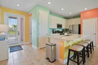 a kitchen with colorful walls and bar stools at Surfstyle at Margaritaville by Shine Villas 022 villa in Orlando