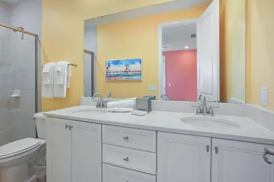 a bathroom with two sinks and a toilet and a mirror at Surfstyle at Margaritaville by Shine Villas 022 villa in Orlando