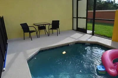 a pool with a table and chairs and a table and chairs at 1320 - Aladin Cozy Bella Vida Kissimmee Close Disney in Kissimmee