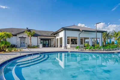 a swimming pool in front of a house at Chic Retreat - Unforgettable Stay in Kissimmee