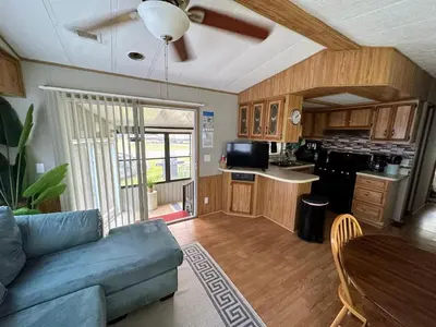 a living room with a blue couch and a kitchen at 15 min to Disney World, Self-check-in, Full Kitchen in Kissimmee
