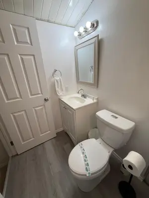 a white bathroom with a toilet and a sink at 15 min to Disney World, Self-check-in, Full Kitchen in Kissimmee