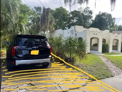 a car parked on a yellow painted parking lot at Cozy Vintage Bungalow @Mills50 District in Orlando