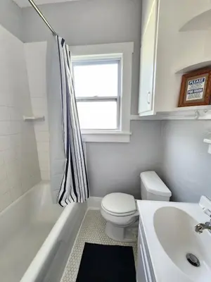 a white bathroom with a toilet and a sink at Cozy Vintage Bungalow @Mills50 District in Orlando