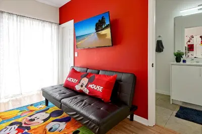 a living room with a couch and a red wall at Magical Serenity in Orlando