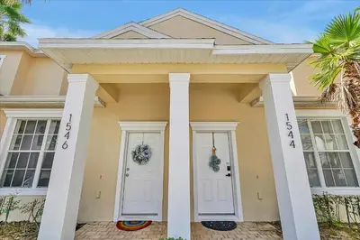 a yellow house with white doors and columns at Magical Serenity in Orlando