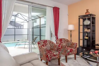a living room with a couch and chairs and a pool at Home 6BR - Prime Location in Kissimmee