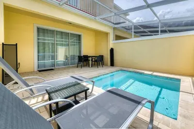 a swimming pool with chairs and a table in a house at Ultimate Getaway - Your Best Vacation Home in Orlando