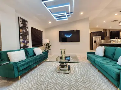 a living room with two green couches and a table at The Villa Orlando College Park Sleeps16 - Monthly Stays in Orlando
