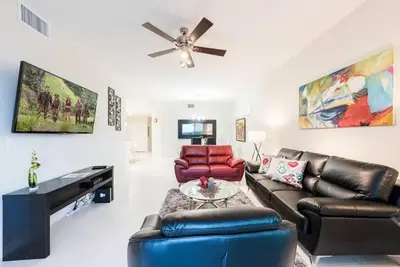 a living room with leather furniture and a ceiling fan at Apartment 3BR Great Location - Super Comfort in Kissimmee
