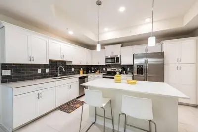 a large white kitchen with white cabinets and appliances at Apartment 3BR Great Location - Super Comfort in Kissimmee