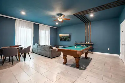 a living room with a pool table and a couch at New Home 8 Bedrooms and 5 Bathrooms At Storey Lake in Kissimmee