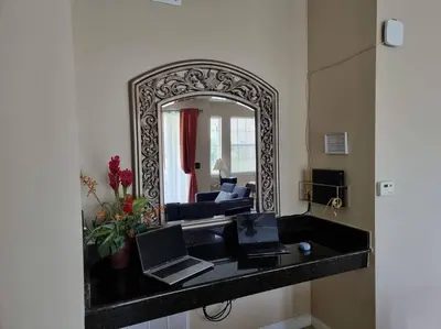 a living room with a mirror and two laptops on a counter at Comfortable Apartment, Close to Disney World in Kissimmee