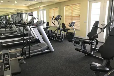 a gym with several treadmills and cardio machines at Comfortable Apartment, Close to Disney World in Kissimmee