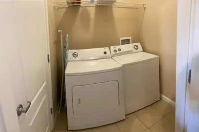 a white washer and dryer in a small room at Comfortable Apartment, Close to Disney World in Kissimmee