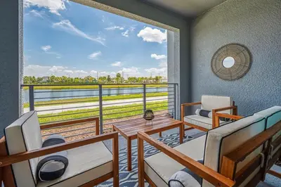 a room with a balcony with a table and chairs at Modern Luxe Condo - Stunning Design in Kissimmee