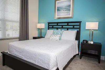 a bedroom with a large bed with blue walls at Charming Cozy Haven in Orlando