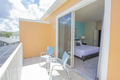 a room with a balcony with a bed and a bedroom at Charming Cozy Haven in Orlando
