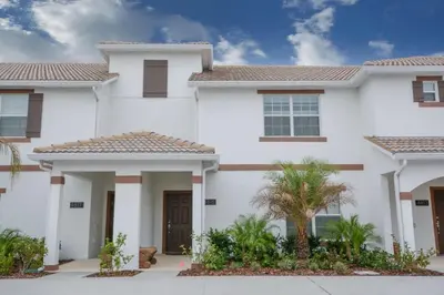 a white house with palm trees in front of it at Spacious Cozy Comfort in Every Corner in Kissimmee