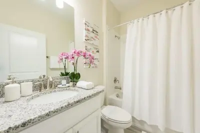 a white bathroom with a sink and a toilet at Chic Luxury Haven - Unforgettable Retreat in Kissimmee