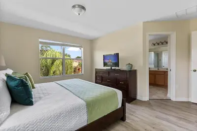 a bedroom with a bed and a window and a television at Enjoy the Large Pool - 6BR BL220 in Kissimmee